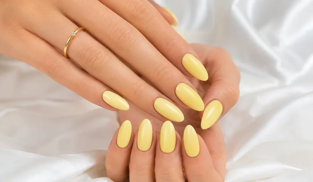 Butter yellow glossy summer nails 2026 with elegant almond nail shape.