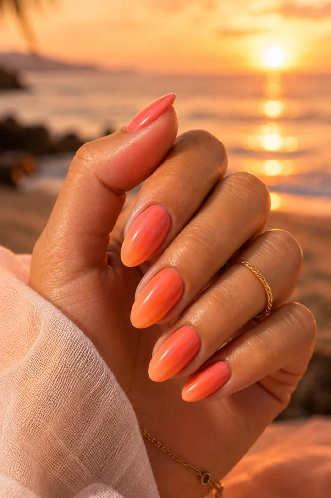 Coral sunset summer nails 2026 with a glossy peach pink gradient
