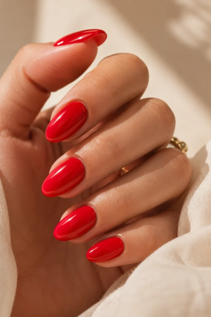Glossy cherry red summer nail color trend 2026 on almond nails
